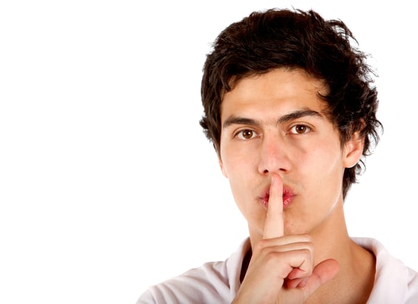 Man making a Be quiet sign isolated over a white background
