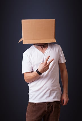 Young man standing and gesturing with a cardboard box on his head-1