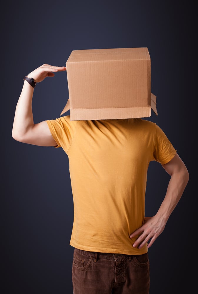 Young man standing and gesturing with a cardboard box on his head